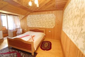 - une chambre avec un lit dans une pièce en bois dans l'établissement Під Піщиком, à Mykulychyn