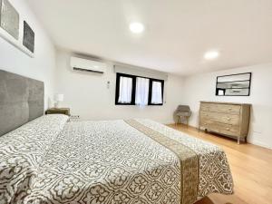 a bedroom with a large bed and a dresser at Duplex zona centro in Villajoyosa