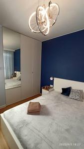 a bedroom with a large bed with a blue wall at Comfy, Familly friendly apartment. Balcony. Garage. in Warsaw