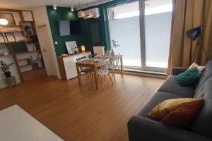 a living room with a couch and a table at Comfy, Familly friendly apartment. Balcony. Garage. in Warsaw