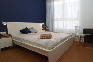 een slaapkamer met een groot bed met een blauwe muur bij Comfy, Familly friendly apartment. Balcony. Garage. in Warschau