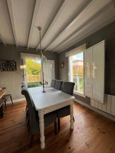 a dining room with a white table and chairs at Villa Rosa bella in Po