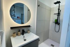 Baño blanco con lavabo y espejo en Appartement rénové proche du parc de la tête d'or, en Villeurbanne