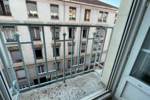 una ventana con vistas a un edificio en Appartement rénové proche du parc de la tête d'or en Villeurbanne