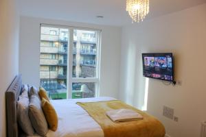 um quarto com uma cama e uma televisão na parede em Stunning two bedroom apartment em Londres