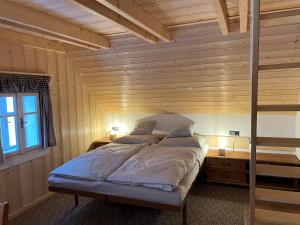 1 dormitorio con 1 cama en una habitación de madera en Chaloupka, en Rokytnice nad Jizerou