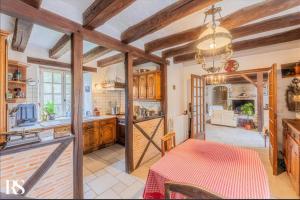 una cocina con techos de madera y una mesa en una habitación en Belle et calme maison de campagne en Artannes-sur-Indre