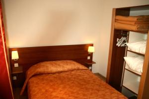 sypialnia z łóżkiem z pomarańczowym kocem w obiekcie Résidence Maison Blanche w mieście Plombières-les-Bains