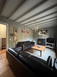 un soggiorno con mobili in pelle nera e un tavolo di Villa Rosa bella a Poo de Llanes