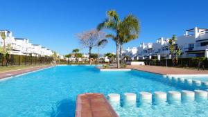 a large swimming pool with palm trees and buildings at Condado de Alhama, Alhama de Murcia N549 in Murcia