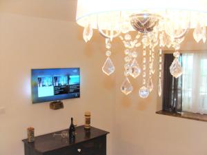 a chandelier in a living room with a tv at Studio stonehouse in Ičići