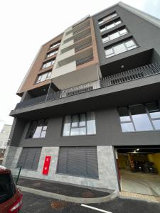 een gebouw met een rode auto ervoor geparkeerd bij Apartment Bjelasnica Mara in Bjelašnica