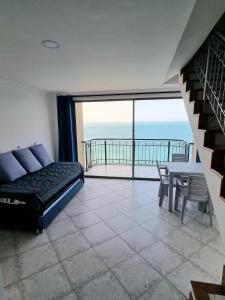 Un dormitorio con una cama y una mesa y un balcón. en Balcón del Infinito, en Santa Marta