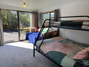 a bedroom with two bunk beds and a sliding glass door at 90 Chalet Crescent in Hanmer Springs