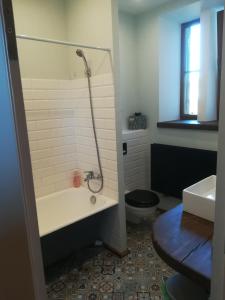a bathroom with a tub and a toilet and a sink at Art Illery Apartment in Rīga
