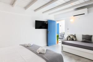 a bedroom with a bed and a blue door at ELEVEN KEYS APARTMENTS in Vrisi/ Mykonos