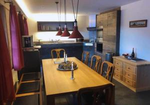 a kitchen with a wooden table and chairs in it at Luxury Chalet Solidage in Rougemont