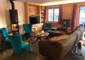 ein Wohnzimmer mit einem Sofa, einem Tisch und Stühlen in der Unterkunft Luxury Chalet Solidage in Rougemont