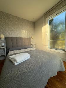 una camera da letto con un grande letto con una grande finestra di Villa Rosa bella a Poo de Llanes
