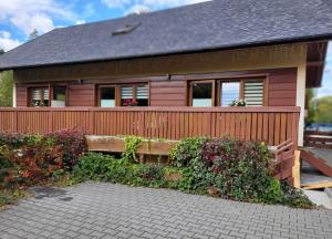 a house with a wooden fence and a bench at Willa Dona in Wisła