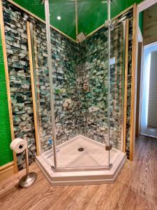 una ducha con puerta de cristal en una habitación en The Tatman Evergreen Suite, en Lake Alfred