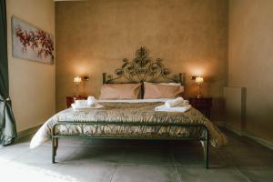 1 dormitorio con 1 cama con 2 toallas en Masseria PerBacco Country House, en Bellona