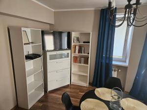 a dining room with a table and a book shelf at Apartament blisko jeziora in Ełk