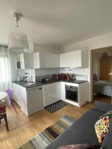 a kitchen with white cabinets and a living room at le cap in San-Martino-di-Lota