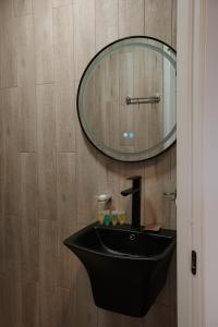 クヴァレリにあるLunisi Kvareliのバスルーム(黒い洗面台、鏡付)