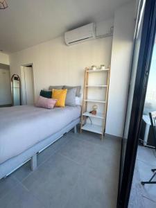 Un dormitorio con una cama con almohadas de colores. en Departamento Palermo Hollywood monoambiente en Buenos Aires