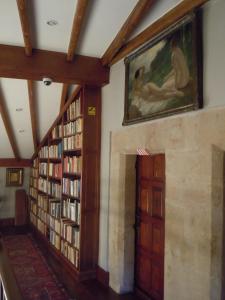 
a room with a wall of books and paintings on it at Palacio Chaves Hotel in Trujillo
