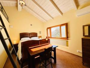 Casa Mina(Wi-fi & TV) في Serralunga di Crea: غرفة نوم مع سرير ومكتب مع مكتب