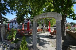 un patio con sombrillas rojas, mesas y sillas en Fürstensteiner Hof en Fürstenstein