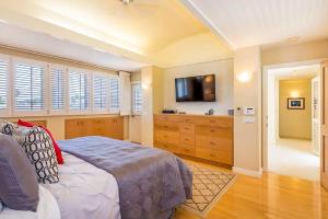 a bedroom with a bed and a flat screen tv at Villa Ahina in Honolulu