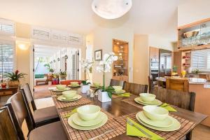 a dining room with a table with chairs and a kitchen at Villa Ahina in Honolulu