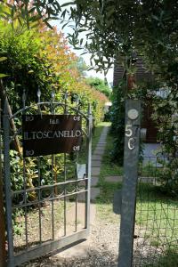 a gate with a sign in front of a garden at Il Toscanello in Lido di Camaiore
