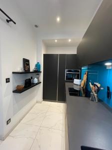 a kitchen with blue and white walls and a counter at Cosy Fourbastard in Toulouse +8 photos