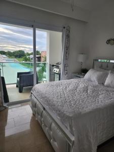 a bedroom with a bed and a view of a pool at New Casino, beach and golf condo at Hard Rock Punta Cana area in Punta Cana