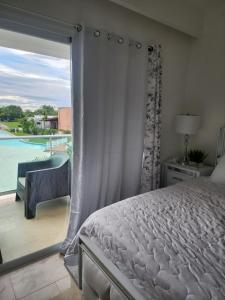 una camera con letto e un balcone con piscina di New Casino, beach and golf condo at Hard Rock Punta Cana area a Punta Cana