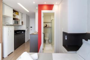 a room with a kitchen and a room with a bathroom at Canal do Anfitrião | Studios delicinhas in Sao Paulo