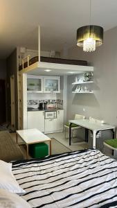Cet appartement comprend une chambre avec un lit et une table ainsi qu'une cuisine. dans l'établissement White Tiger in New Gudauri II, à Goudaouri