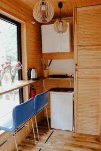 a kitchen with two blue chairs and a table at Domek na Drzewie Radziejowice blisko Suntago in Budy Mszczonowskie