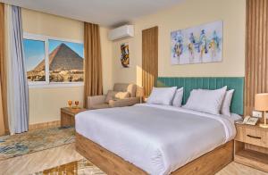 a hotel room with a large bed and a view of the pyramid at Soul Pyramids View in Cairo