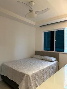 a bedroom with a bed and a ceiling fan at Apartamento encantador in Ilhéus