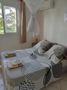 un letto con piumone bianco e nero e una finestra di F2 proche plage Anse Mitan a Les Trois-Îlets Altre 7 foto