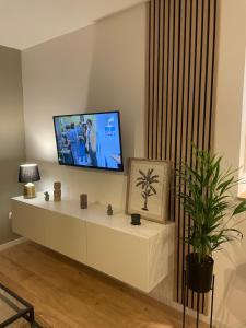 a living room with a tv on a white cabinet at Appartement Cosy Beauvais in Beauvais