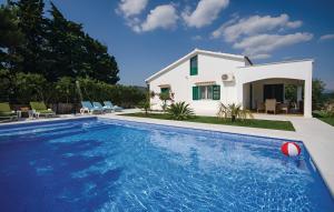 uma villa com piscina em frente a uma casa em Villa Olive Tree em Kaštela