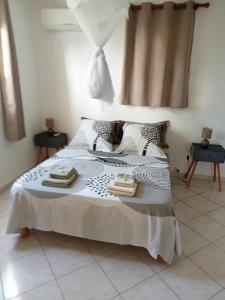 - une chambre avec un lit et 2 serviettes dans l'établissement F2 proche plage Anse Mitan, à Les Trois-Îlets