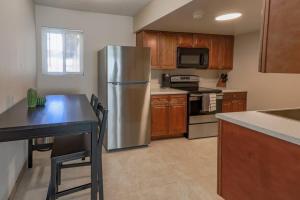 a kitchen with a stainless steel refrigerator and wooden cabinets at Spacious Condo Close to Sphere in Las Vegas