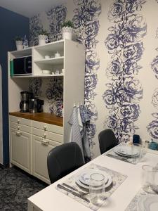 uma cozinha com papel de parede azul e branco e uma mesa em Leon’s Apartment em Krefeld